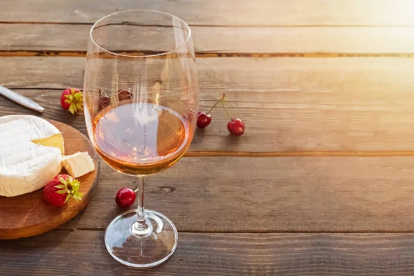 Kieliszek wina różanego stojący na drewnianym stole w stylu rustykalnym — Zdjęcie stockowe