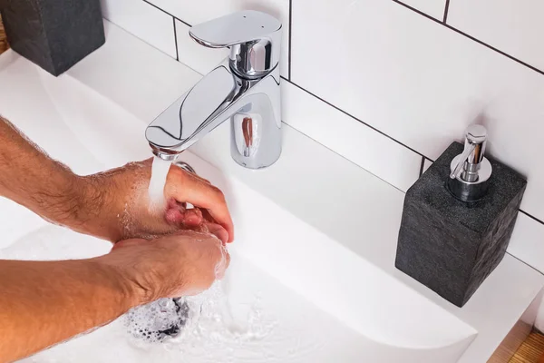आदमी आधुनिक बाथरूम में अपने हाथ धो रहा है . — स्टॉक फ़ोटो, इमेज