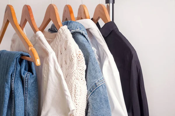 Ropa de mujer en blanco y negro en perchas de madera en un estante en una  tienda de moda. armario mujer de negocios