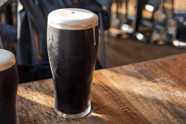 Vaso de cerveza corpulenta de pie sobre la mesa de madera — Foto de Stock