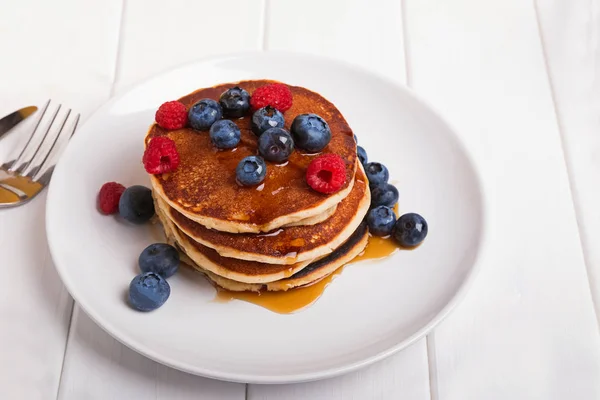 Stack of delicious homemade pankes with berries on the white plate — Stock Photo, Image