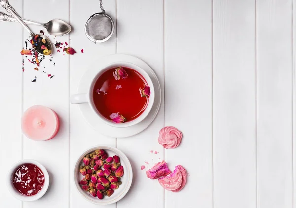 Thé floral avec des roses et autres accessoires de l'heure du thé sur table en bois blanc — Photo