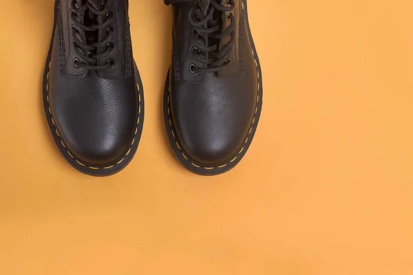 Lederstiefel auf gelbem Hintergrund mit Kopierraum — Stockfoto