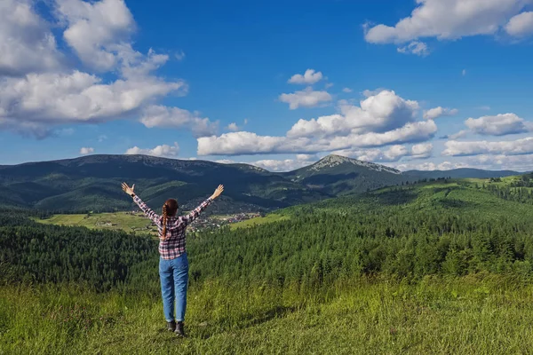 Jovem viajante de pé em montanhas de verão com as mãos levantadas — Fotografia de Stock