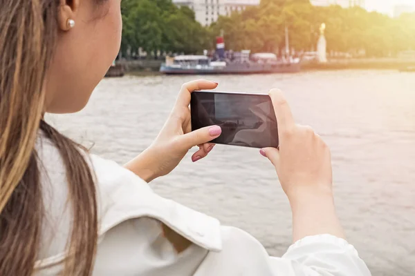 Young woman taking photo with her mobile phone in the city — Stock Photo, Image