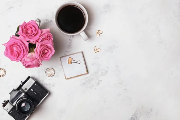 Koffie, rozen, retro camera en gouden briefpapier op de marmeren achtergrond — Stockfoto