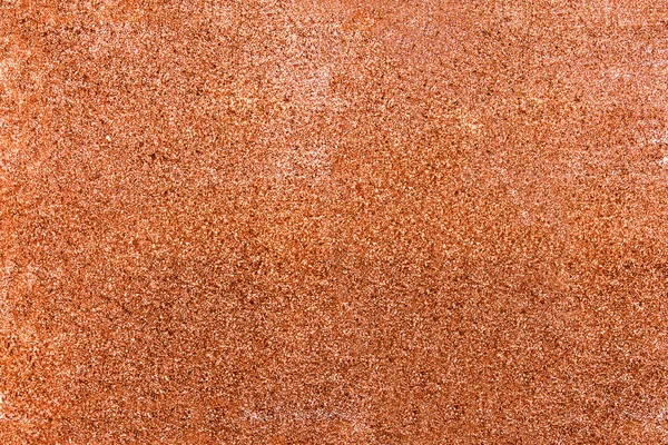 Texture with rose gold sparkles on surface.