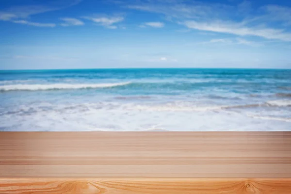 Lege houten tafel voor weergave op de achtergrond van wazig strand — Stockfoto