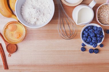 Ahşap masa üzerinde yaban mersini kekler hazırlık için Malzemeler, üst görünümü.