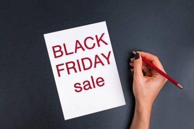 Kartın yanında eli kalem tutan kadınlar Kara Cuma indirimi yapıyorlar.