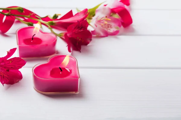 Twee hartvormige kaarsen op de witte houten tafel — Stockfoto