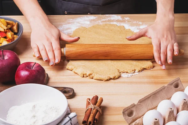 Жінки руки крупним планом розкачують тісто для яблучного пирога — стокове фото