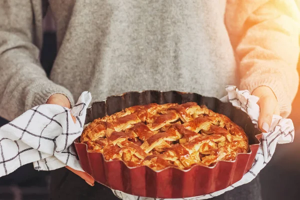 Mãos das mulheres segurando torta de maçã caseira cozida fresca — Fotografia de Stock