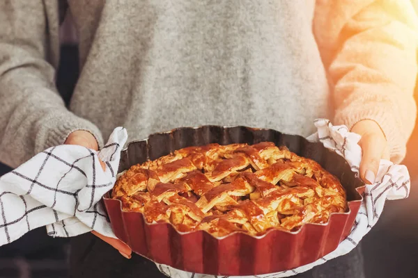 Kvinnors händer håller nybakad hemlagad äppelpaj — Stockfoto