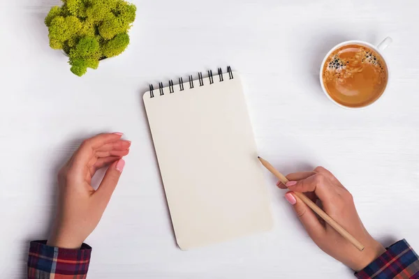 Womans hands hand pencil near the empty notepad on white office desk — Stock Photo, Image