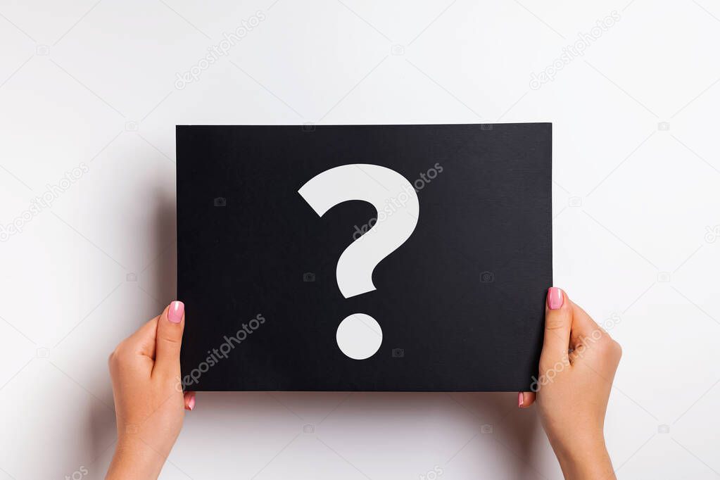 Womans hands holding black paper with white answer sign