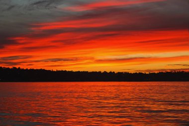 Güzel kızıl gökyüzü, denizin üstünde bulutlar