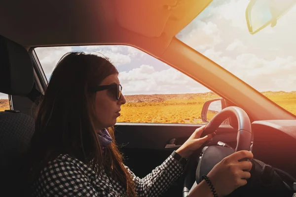 Jeune femme voyageuse conduisant une voiture sur une petite route de campagne — Photo