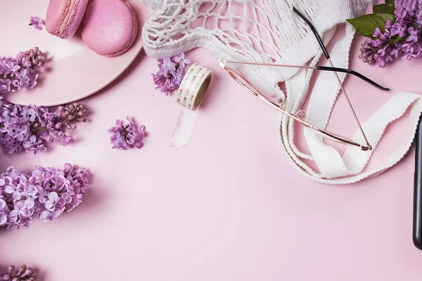 Lente plat lag met lila bloemen, glazen en macarons — Stockfoto