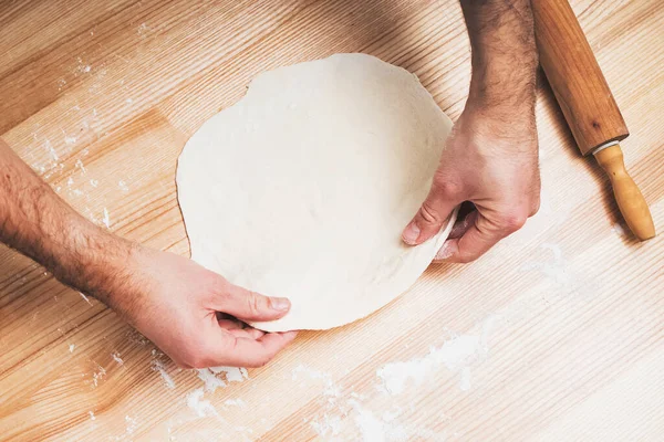 Mans mains travaillant avec de la pâte sur une table en bois, — Photo