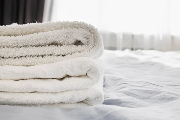 Pile of clean white towels on the bed — Stock Photo, Image