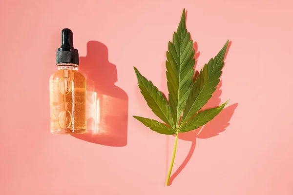 Aceite de cáñamo y hoja de cannabis aislados sobre fondo blanco. Aceite de cannabis saludable. — Foto de Stock