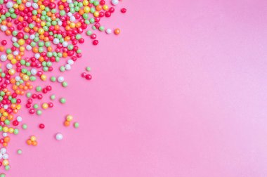 Dekoratif şeker, pembe bir fonda serpiştirir..