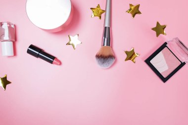 Güzellik ürünleri pembe arka planda yatıyordu.