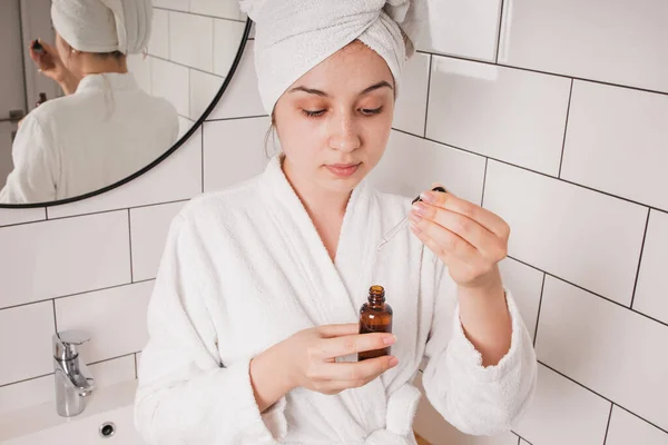 Joven bonita mujer después de la ducha va a aplicar cuidado de la piel produc — Foto de Stock