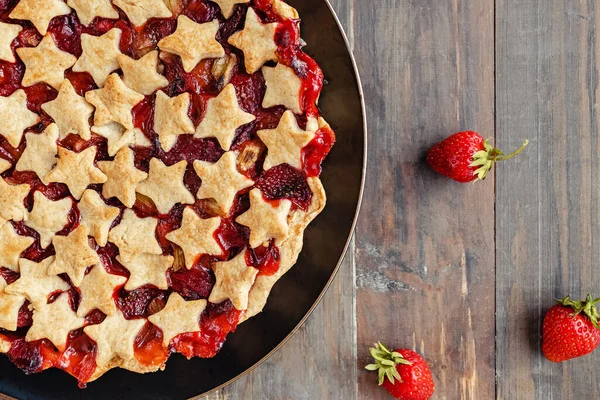 Strawberry and rhubarb pie decorated with stars on white table, top view — Stock Photo, Image