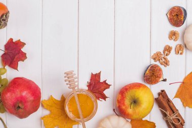 Sarı ve yeşil arka planda nar ve kuru yapraklar. Yaratıcı Sonbahar yerleşimi. Sınır düzenlemesi. Düz manzaralı. Boşluğu kopyala.