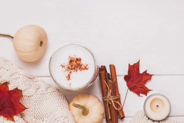 Kopp kaffe med mjölk och kanel, höstlöv och pumpor — Stockfoto