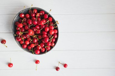 Beyaz ahşap masada olgun kirazlar