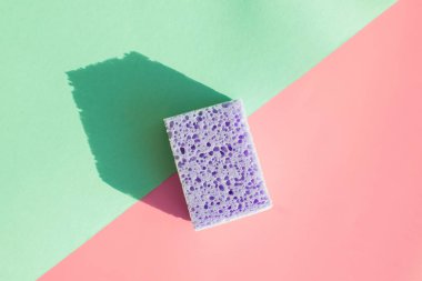 Pastel arka planda bulaşık yıkama süngeri iki tonda. Minimalist temizlik kavramı