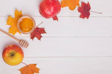 Sarı ve yeşil arka planda nar ve kuru yapraklar. Yaratıcı Sonbahar yerleşimi. Sınır düzenlemesi. Düz manzaralı. Boşluğu kopyala.