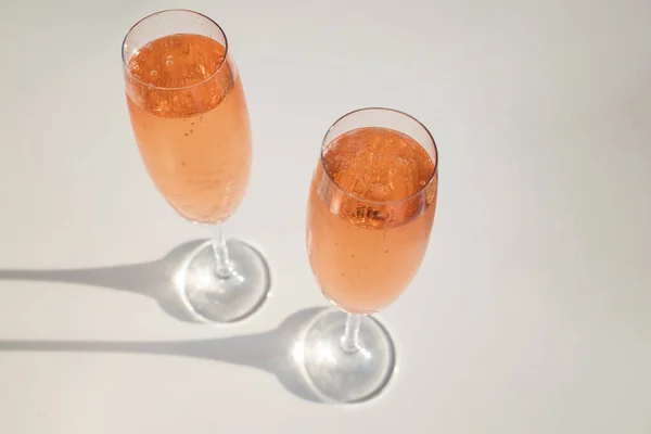 Dois copos com vinho espumante rosa na mesa branca — Fotografia de Stock