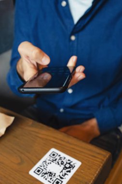 Adam cep telefonuyla QR kodunu tarıyor