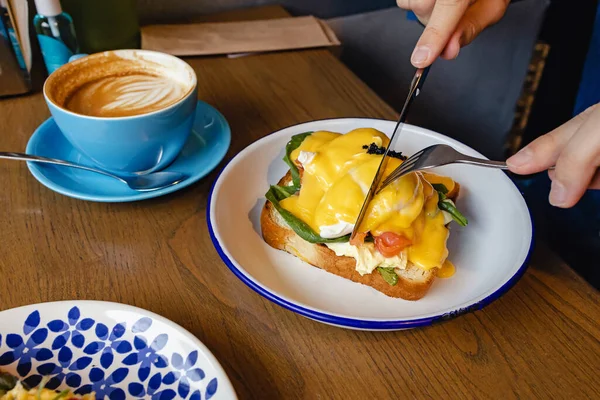 Man eet eieren benedict met mes en vork close-up. — Stockfoto