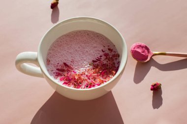 Pembe arka planda bir bardak gül kakule..