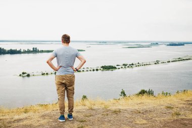 Geniş nehir manzaralı genç bir adam.
