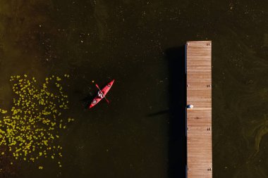 Nehiri geçen yeşil suyun üzerinde bir kanoda bir kadın..