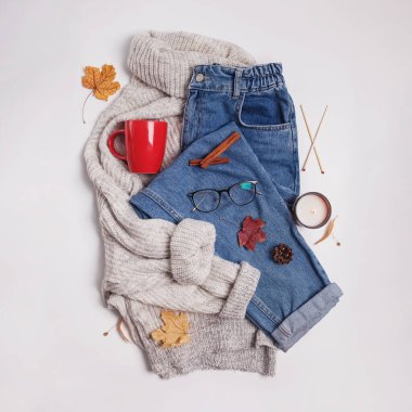 Eans, örgü süveter, kırmızı bardak ve sarı yapraklar beyaz masada, üst manzara