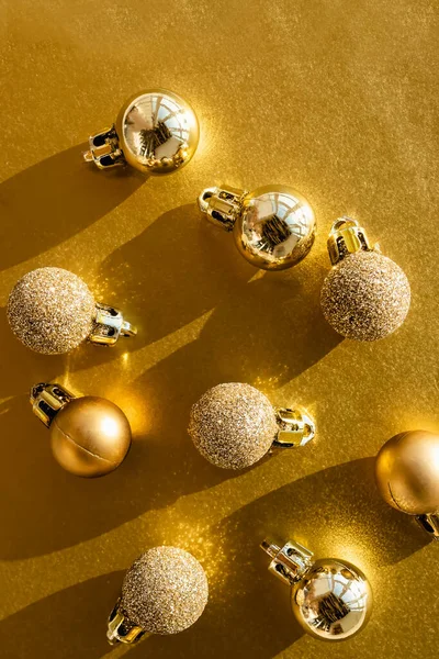 Gouden kleur kerstballen op gouden achtergrond met harde schaduwen. — Stockfoto