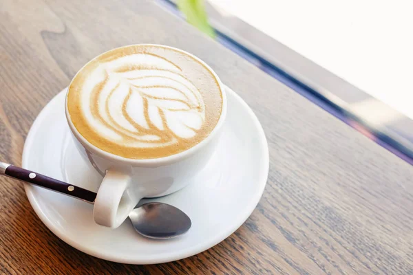 Крупный план горячего кофе капучино с листовой формой латте — стоковое фото