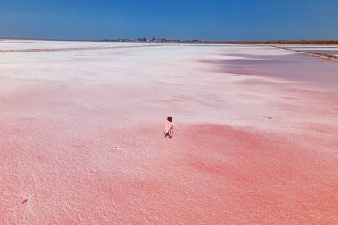 Parlak pembe salin yüzeyinde yürüyen bir kadın.