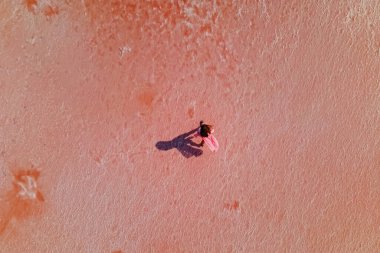 Parlak pembe salin yüzeyinde yürüyen bir kadın.