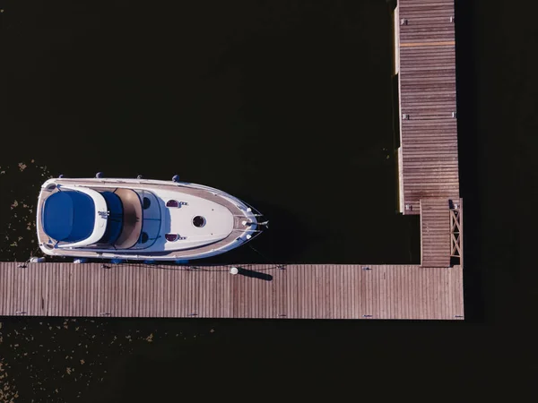 Photo aérienne de petit bateau à moteur ou yacht debout près de la jetée en bois — Photo