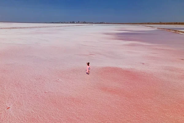 Parlak pembe salin yüzeyinde yürüyen bir kadın.