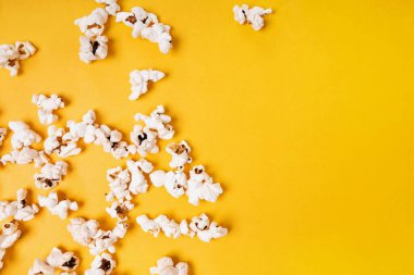 Patlamış mısır parlak sarı arka planda, üst görünümde, kopyala alanı