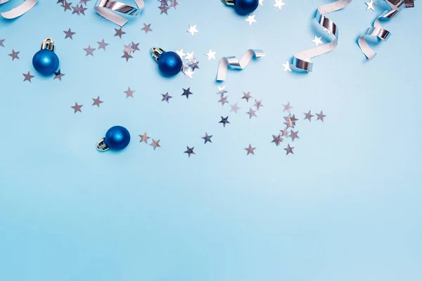 Feestelijke Kerstdecor Blauwe Achtergrond Sterrenvormpjes Confetti Wervelingen Kerstballen Vlakke Lay — Stockfoto
